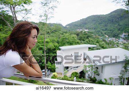Young woman leaning on railing, looking out View Large Photo Image Stock Photo - Young woman leaning on railing, looking out . Fotosearch