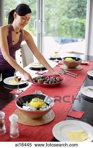 Young woman setting the dining table View Large Photo Image Stock Photography - Young woman setting the dining table . Fotosearch