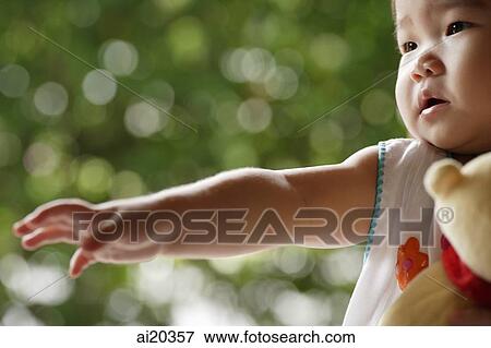 Baby girl, looking away, arm outstretched View Large Photo Image Stock Photo - Baby girl, looking away, arm outstretched. Fotosearch