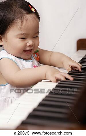 Baby girl playing the piano, smiling View Large Photo Image Stock Image - Baby girl playing the piano, smiling. Fotosearch