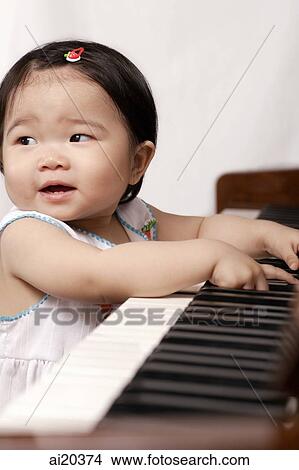 Baby girl sitting by piano, looking away View Large Photo Image Picture - Baby girl sitting by piano, looking away. Fotosearch