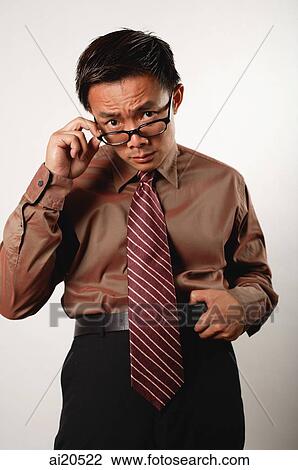 Businessman adjusting his black glasses looking at camera View Large Photo Image Stock Image - Businessman adjusting his black glasses looking at camera. Fotosearch
