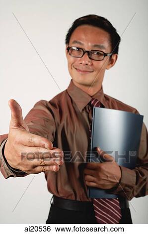 Businessman holding notebook, extending hand to camera View Large Photo Image Stock Photograph - Businessman holding notebook, extending hand to camera. Fotosearch