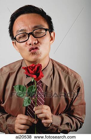 Stock Photo - Businessman holding rose, puckering mouth. Fotosearch