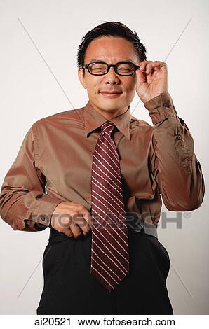 Stock Image - Businessman in black glasses looking at camera. Fotosearch