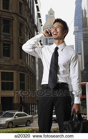 Businessman in the city, using mobile phone View Large Photo Image Stock Image - Businessman in the city, using mobile phone. Fotosearch