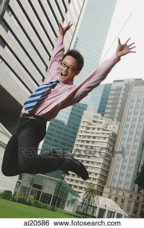 Businessman jumping in the air, arms outstretched View Large Photo Image Stock Photograph - Businessman jumping in the air, arms outstretched. Fotosearch