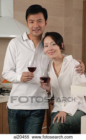 Couple in kitchen, holding wine glasses, looking at camera, portrait View Large Photo Image Stock Photography - Couple in kitchen, holding wine glasses, looking at camera, portrait. Fotosearch