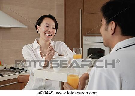 Couple sitting in kitchen, having breakfast View Large Photo Image Stock Photo - Couple sitting in kitchen, having breakfast. Fotosearch