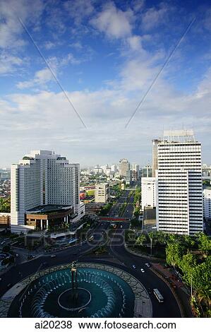 Stock Photo - Late afternoon view of the Hotel Indonesia roundabout, Welcome monument and buildings along Jalan Thamrin, Jakarta. Fotosearch