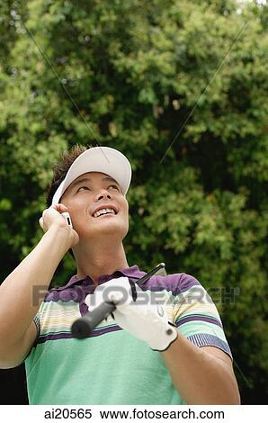 Male golfer using mobile phone, looking up, smiling View Large Photo Image Stock Photography - Male golfer using mobile phone, looking up, smiling. Fotosearch