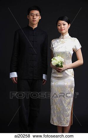 Man and woman dressed in traditional Chinese attire, woman holding bouquet View Large Photo Image Stock Photo - Man and woman dressed in traditional Chinese attire, woman holding bouquet. Fotosearch