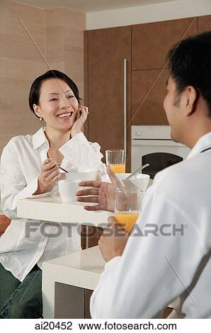 Man and woman sitting in kitchen, having breakfast View Large Photo Image Stock Image - Man and woman sitting in kitchen, having breakfast. Fotosearch