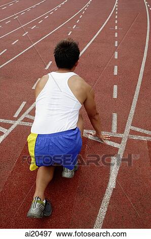 Man at running track in starting position, high angle view View Large Photo Image Stock Photo - Man at running track in starting position, high angle view. Fotosearch