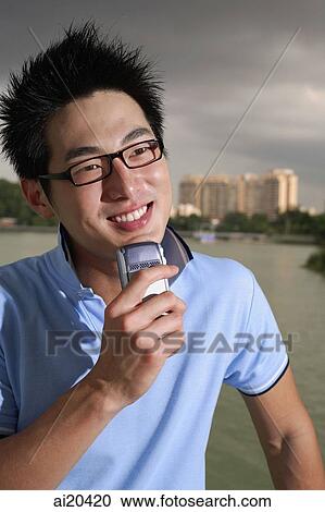 Man holding mobile phone, looking away View Large Photo Image Stock Image - Man holding mobile phone, looking away. Fotosearch