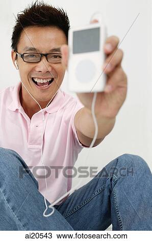 Man holding MP3 player towards camera View Large Photo Image Stock Image - Man holding MP3 player towards camera. Fotosearch