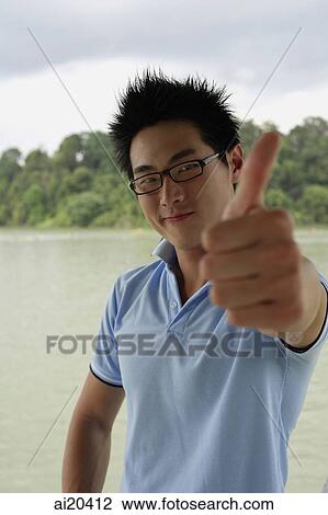 Man in blue polo shirt, smiling, making a thumbs up sign View Large Photo Image Stock Image - Man in blue polo shirt, smiling, making a thumbs up sign. Fotosearch