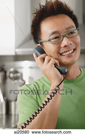 Man in kitchen, using telephone View Large Photo Image Stock Image - Man in kitchen, using telephone. Fotosearch