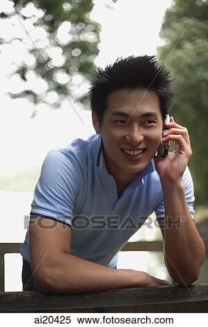 Man in polo shirt using mobile phone, body of water in background View Large Photo Image Stock Photography - Man in polo shirt using mobile phone, body of water in background. Fotosearch