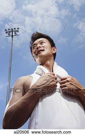 Man in sleeveless T shirt with towel around his neck, looking away, low angle view View Large Photo Image Stock Photograph - Man in sleeveless T shirt with towel around his neck, looking away, low angle view. Fotosearch