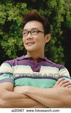 Man in striped polo shirt, arms crossed, smiling View Large Photo Image Stock Photo - Man in striped polo shirt, arms crossed, smiling. Fotosearch