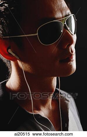 Stock Photography - Man in sunglasses, wearing earphones. Fotosearch
