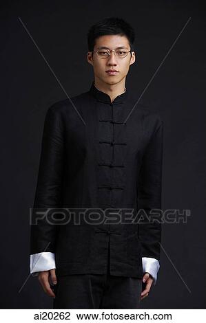 Stock Image - Man in traditional attire, looking at camera. Fotosearch