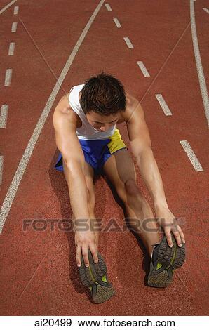 Man on running track, sitting and touching his toes View Large Photo Image Stock Photo - Man on running track, sitting and touching his toes. Fotosearch