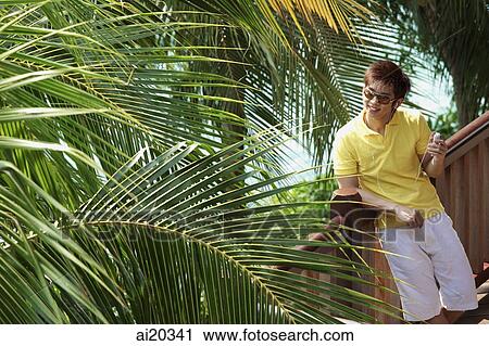 Stock Image - Man outdoors listening to Mp3 player. Fotosearch
