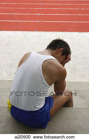 Man sitting with hand on head, running track in background View Large Photo Image Stock Image - Man sitting with hand on head, running track in background. Fotosearch