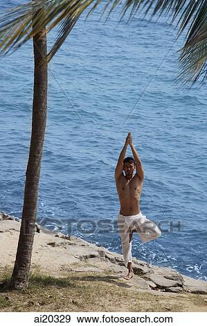Man standing on the beach, practicing yoga View Large Photo Image Stock Photo - Man standing on the beach, practicing yoga. Fotosearch