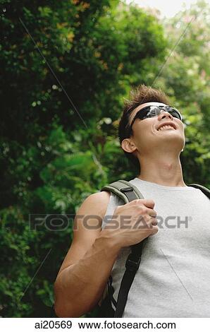 Man with backpack and sunglasses, looking up View Large Photo Image Stock Photo - Man with backpack and sunglasses, looking up. Fotosearch
