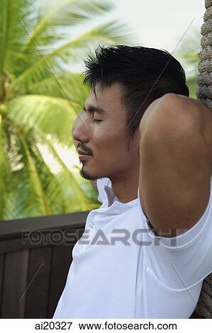 Man with hands behind head, eyes closed View Large Photo Image Stock Photo - Man with hands behind head, eyes closed. Fotosearch