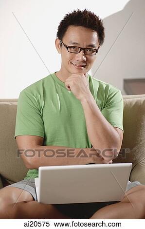 Man with laptop, hand on chin, looking at camera View Large Photo Image Stock Photography - Man with laptop, hand on chin, looking at camera. Fotosearch