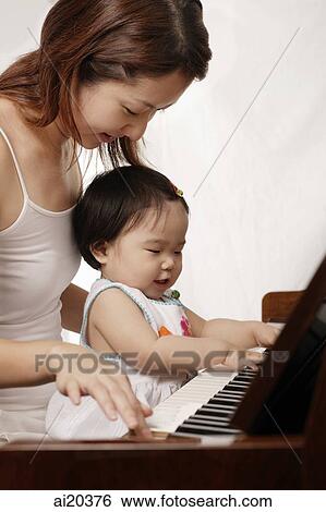 Mother and daughter playing the piano View Large Photo Image Stock Photograph - Mother and daughter playing the piano. Fotosearch