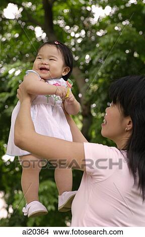 Picture - Mother holding daughter up. Fotosearch