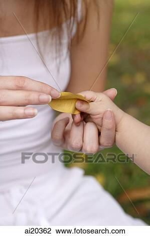 Mother holding daughter's hand, close-up View Large Photo Image Stock Image - Mother holding daughter's hand, close-up. Fotosearch