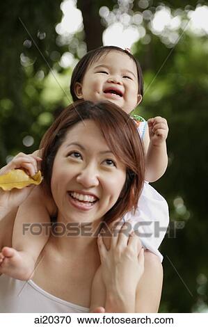 Mother with young daughter on shoulder, smiling View Large Photo Image Stock Image - Mother with young daughter on shoulder, smiling. Fotosearch
