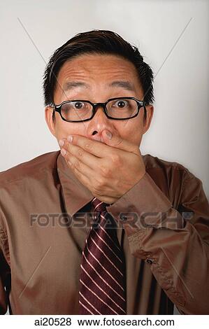 Nerdy businessman covering mouth View Large Photo Image Stock Photo - Nerdy businessman covering mouth. Fotosearch