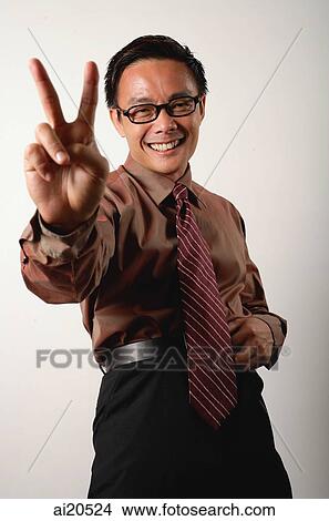 Picture - Nerdy businessman making peace hand sign. Fotosearch