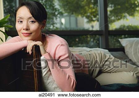 Portrait of a woman lying on sofa View Large Photo Image Stock Image - Portrait of a woman lying on sofa. Fotosearch
