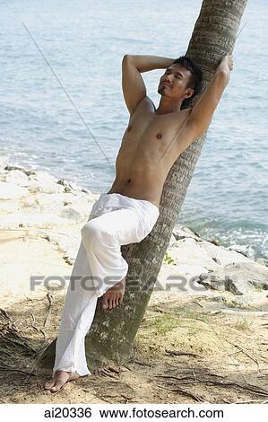 Shirtless man leaning on tree, eyes closed View Large Photo Image Stock Photograph - Shirtless man leaning on tree, eyes closed. Fotosearch