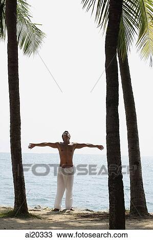Shirtless man standing between trees, arms outstretched View Large Photo Image Stock Image - Shirtless man standing between trees, arms outstretched. Fotosearch
