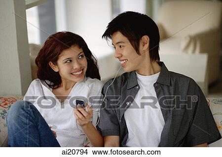 Teenage couple listening to MP3 player View Large Photo Image Picture - Teenage couple listening to MP3 player. Fotosearch