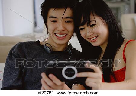 Teenage couple smiling at camera phone View Large Photo Image Stock Image - Teenage couple smiling at camera phone. Fotosearch