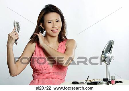 Woman looking at camera, brushing hair View Large Photo Image Stock Image - Woman looking at camera, brushing hair. Fotosearch