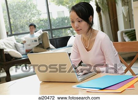 Woman using laptop, man in background reading newspaper View Large Photo Image Stock Image - Woman using laptop, man in background reading newspaper. Fotosearch