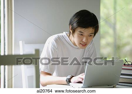 Young man using laptop View Large Photo Image Picture - Young man using laptop. Fotosearch