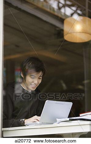 Young man using laptop View Large Photo Image Stock Image - Young man using laptop. Fotosearch