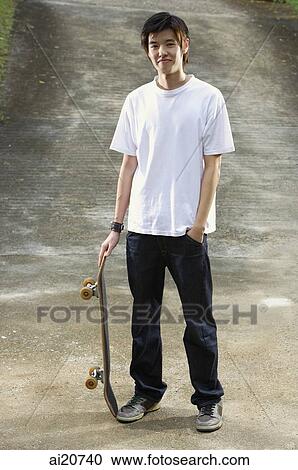 Young man with skateboard, hand in pocket View Large Photo Image Stock Image - Young man with skateboard, hand in pocket. Fotosearch